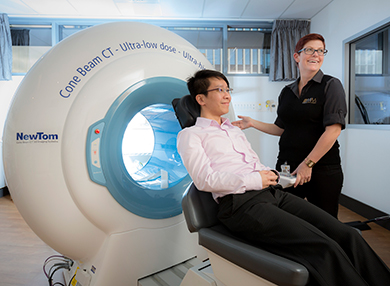 A technician and patient using the CBCT machine