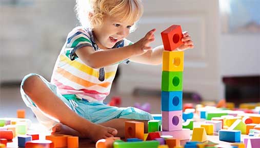 A young child playing with coloured blocks