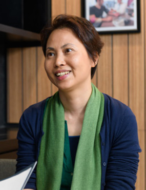Alice Leung, a smiling woman wearing a green scarf.