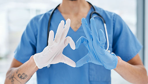 A nurse making a heart shape with their hands