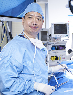 Martin Ng wearing scrubs in an operating theatre.