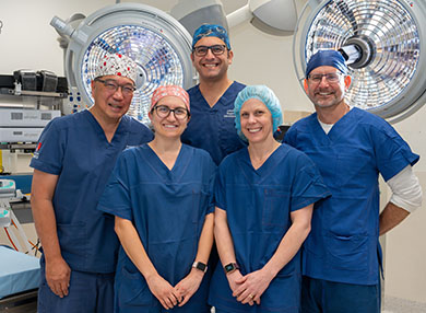 The MQ Health respiratory team dressed in scrubs smiling at the camera.