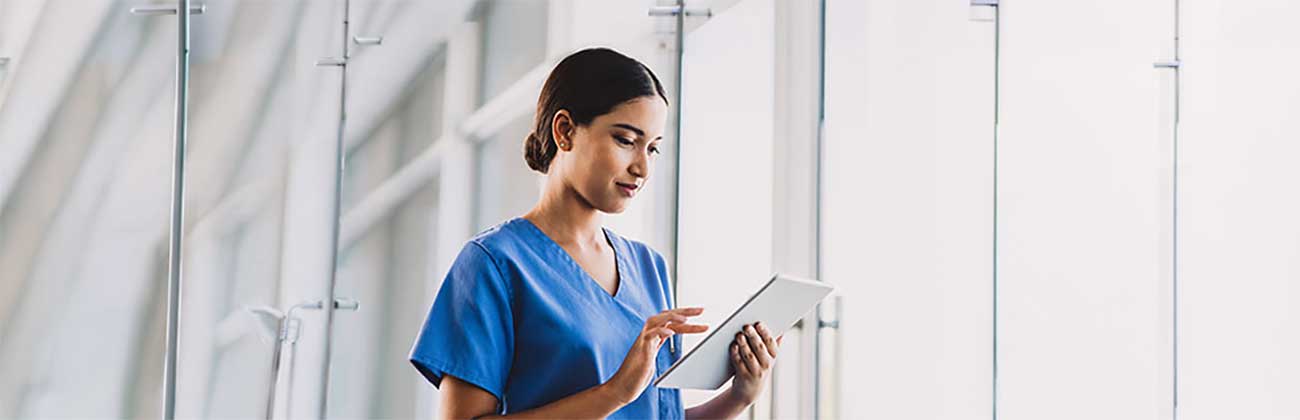A nurse tapping an iPad