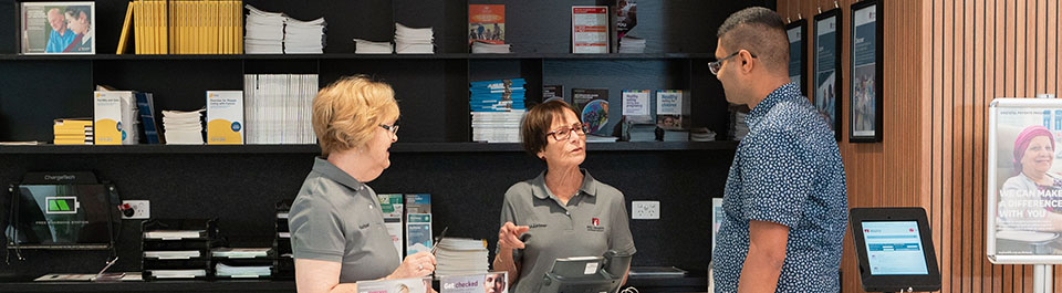 Two volunteers talking to a visitor